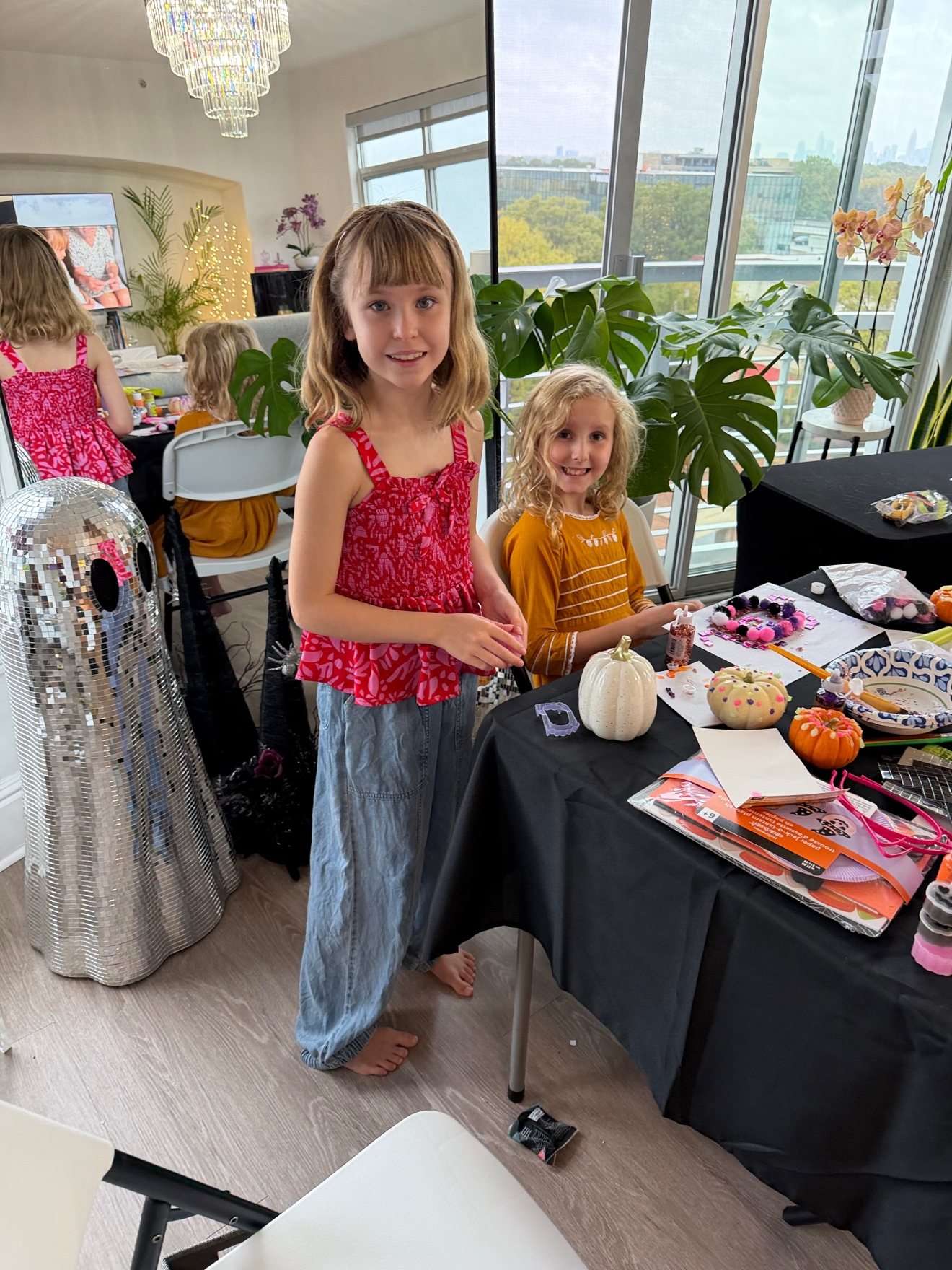 Lily and her friend at the craft table with the disco ghost alongside