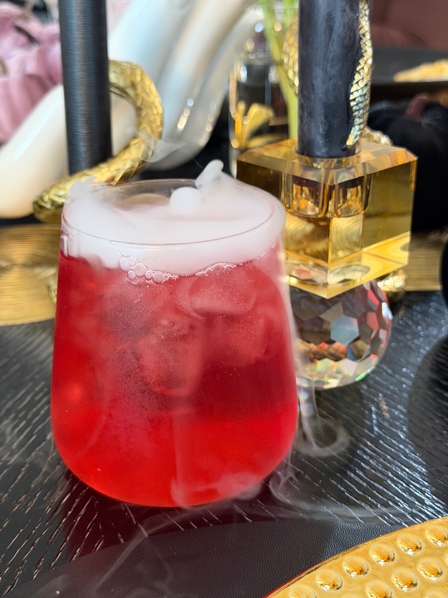 Smoking red Crownberry Apple beside a gold crystal candle holder