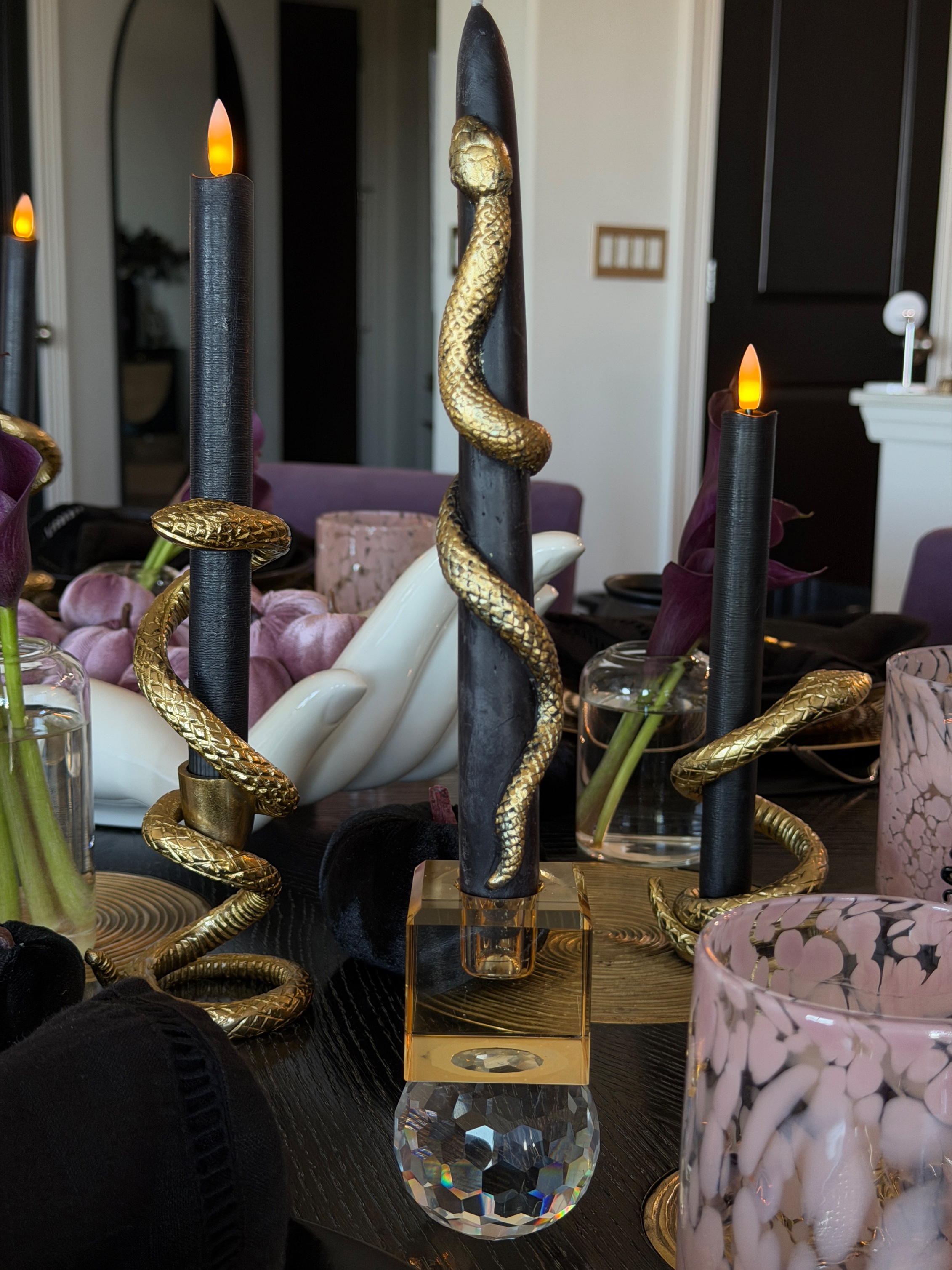 Gold snake candle holders wrapped around black taper candles