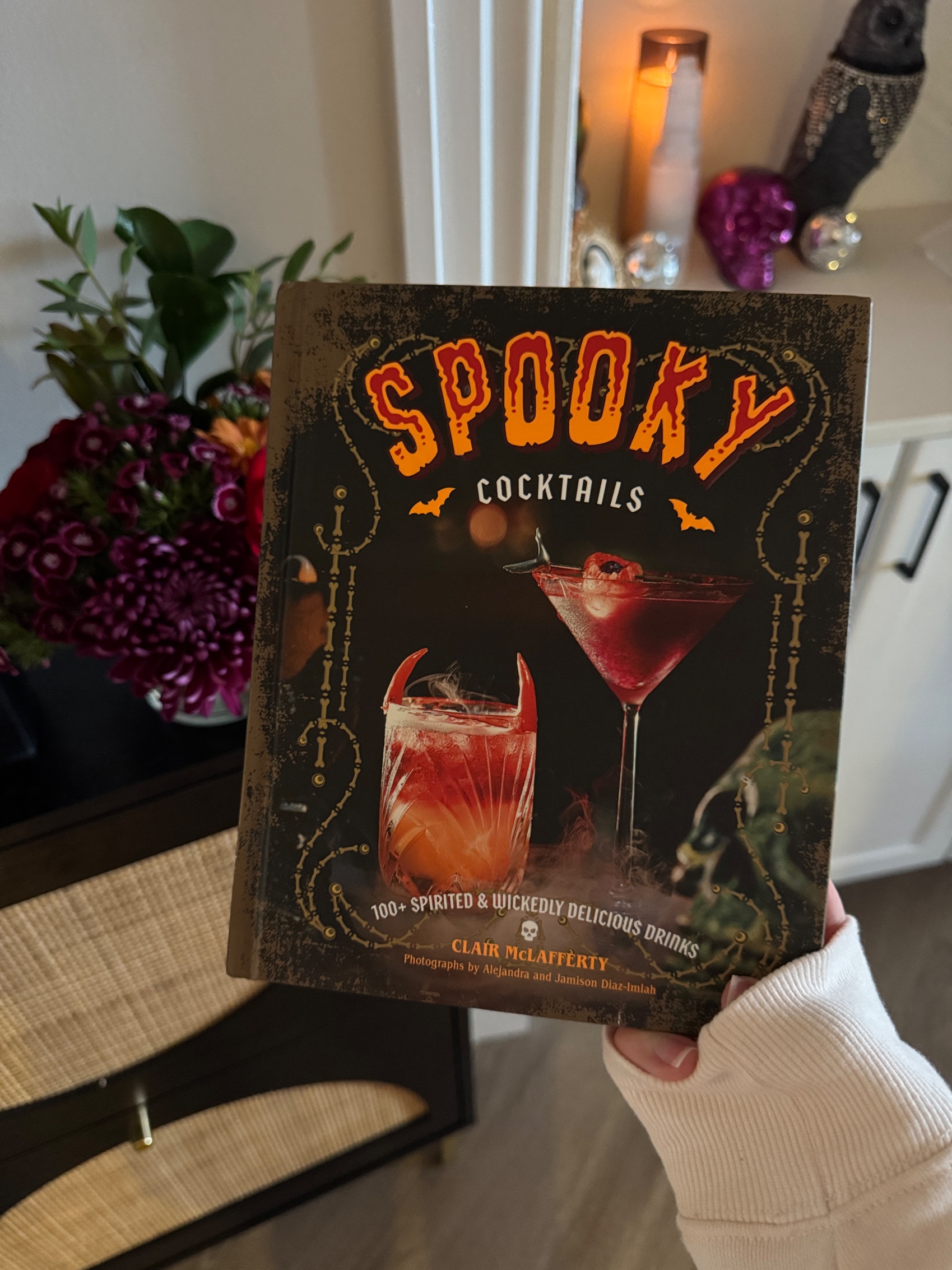 The Spooky Cocktails book by Clair McLafferty, held up at the party