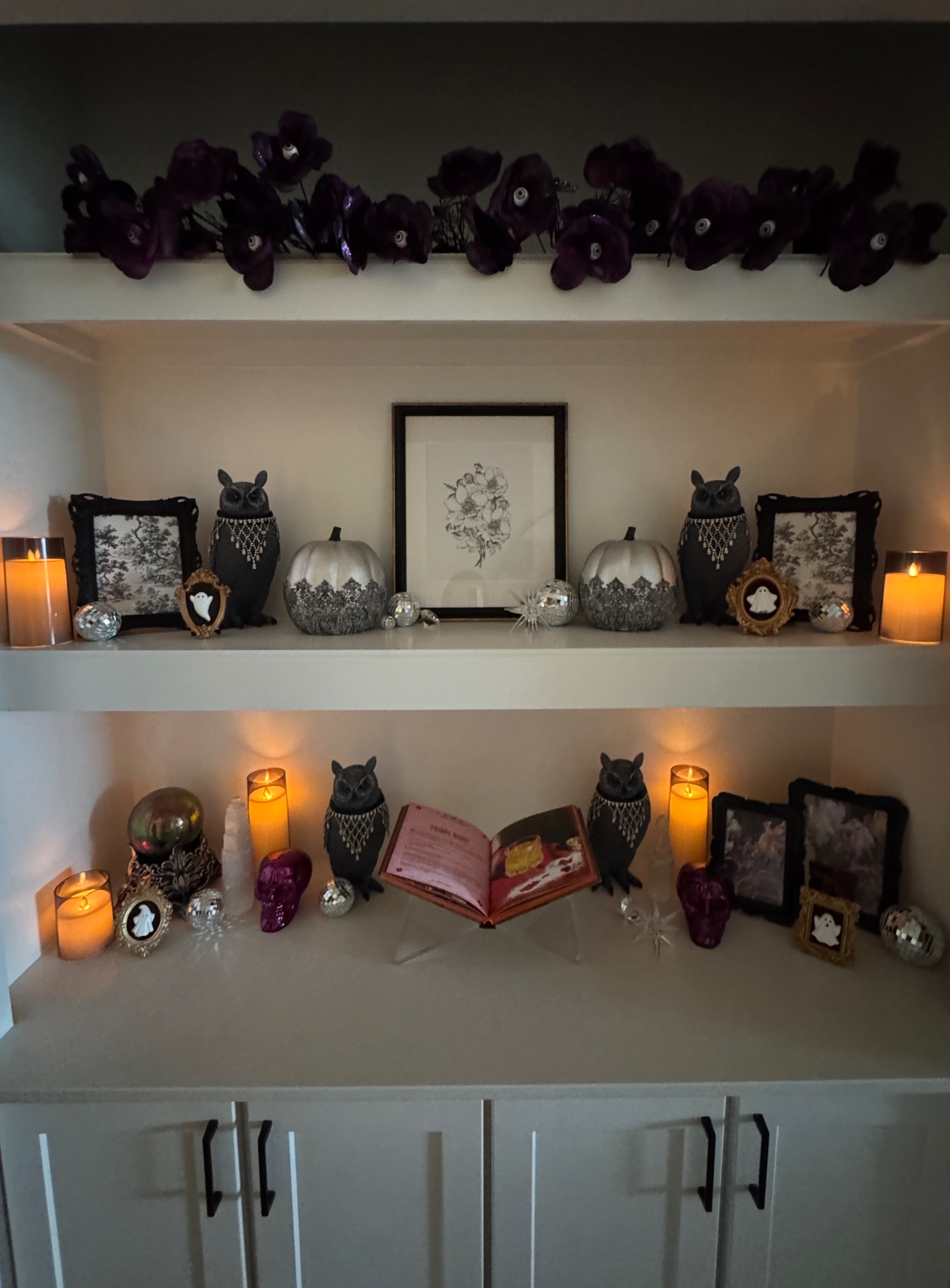 Styled shelves with beaded owls, silver lace pumpkins, ghost cameos, magenta skulls and an eyeball flower garland