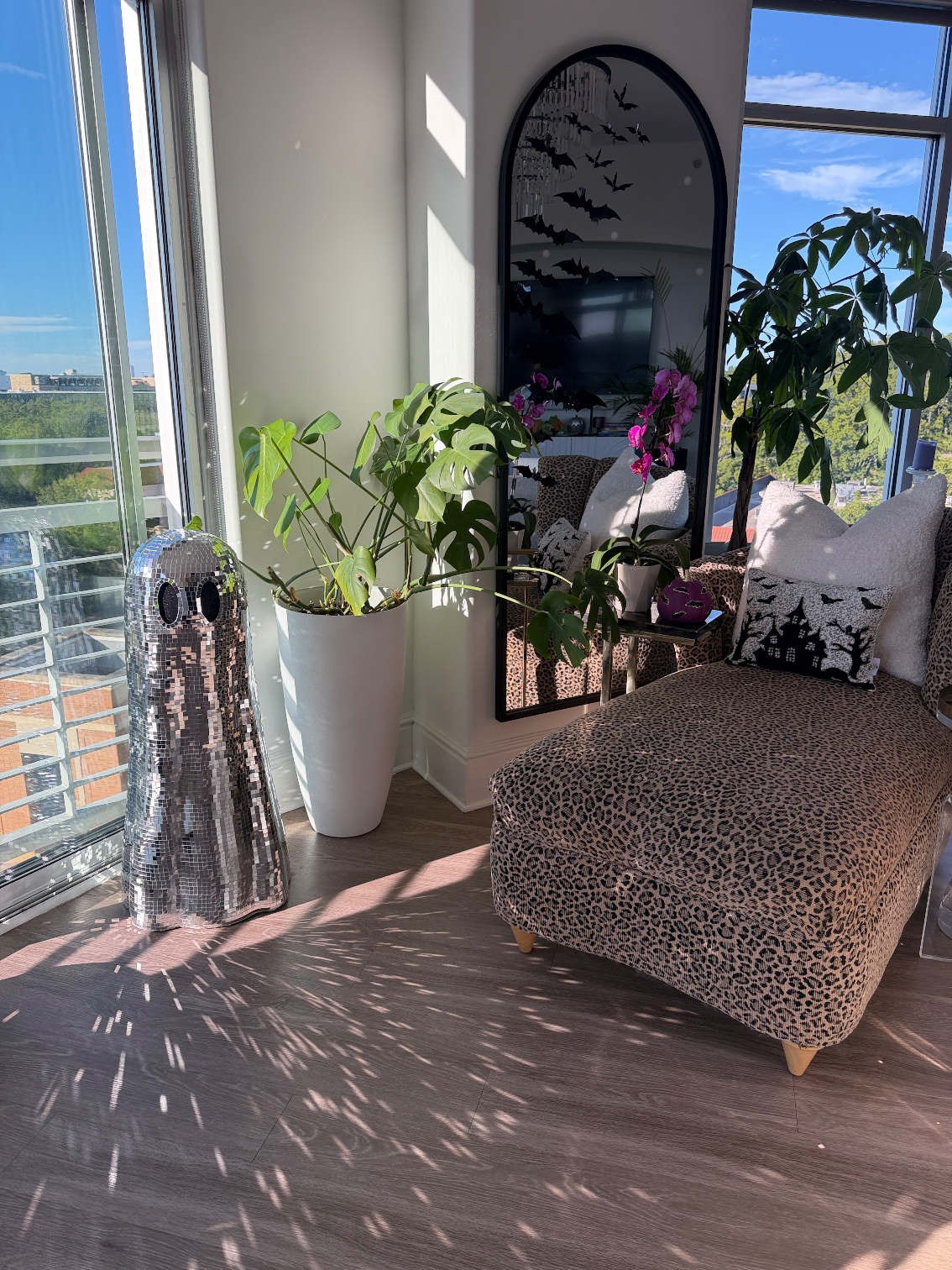 The disco ball ghost by the window next to the leopard chaise, throwing sparkles across the floor