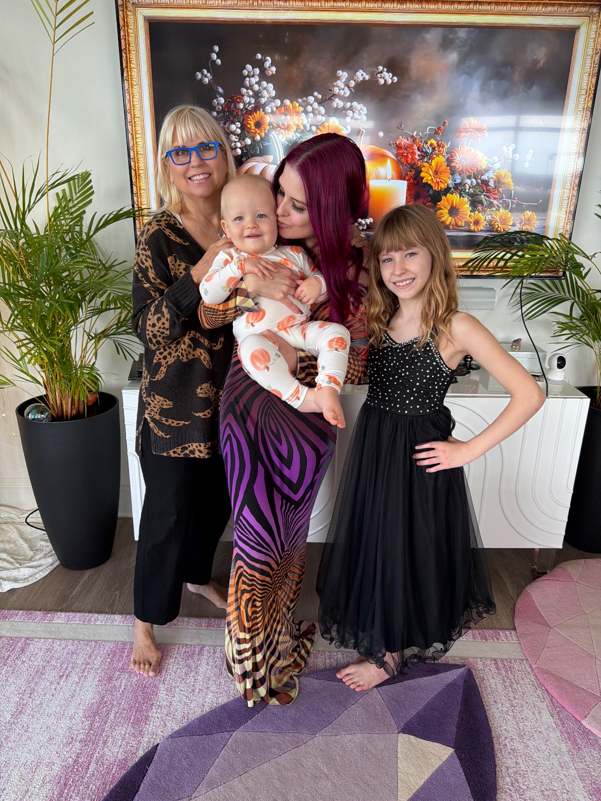 Family at Galloween: Ashley holding baby London in his pumpkin pajamas, with Lily in her sparkle dress