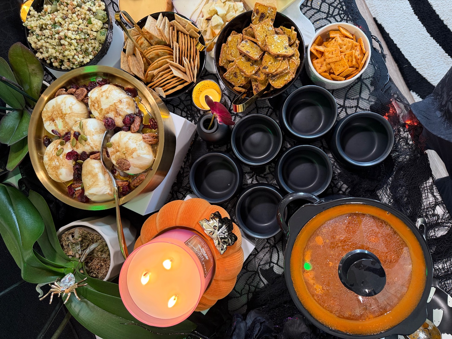 Overhead view of the grazing table from another angle, with the burrata bowl, salad, crackers and the slow cooker of soup