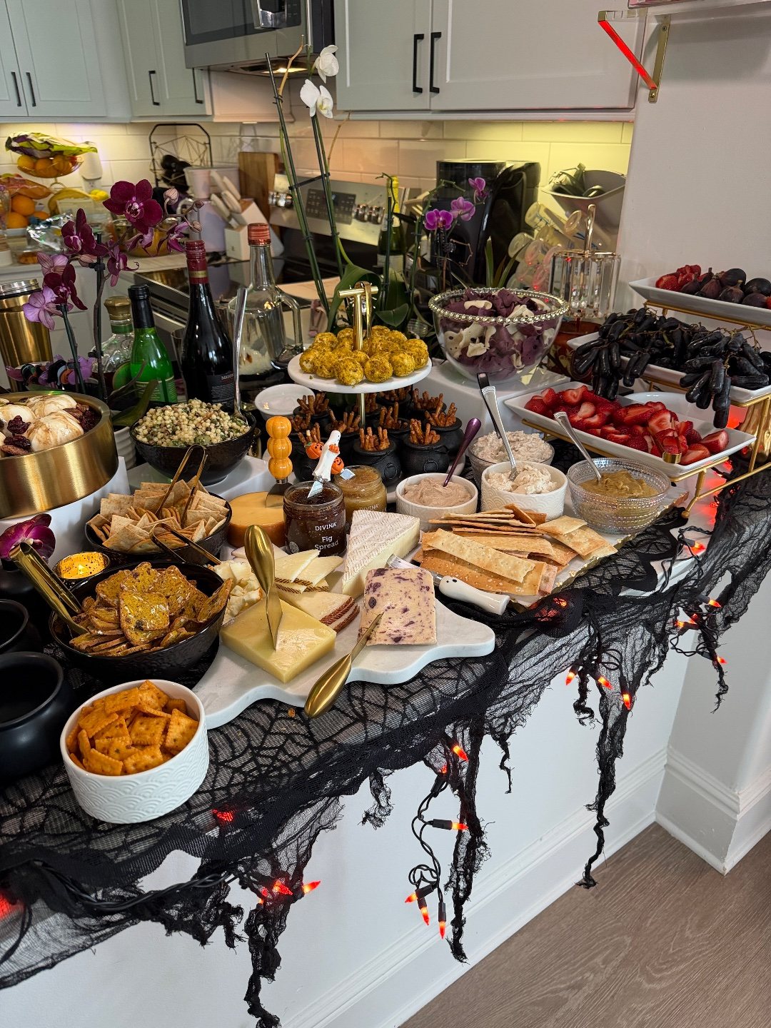 Closer look at the spread: cheese board, burrata with balsamic, fregola salad, ghost chips, pretzel cauldrons and moon grapes