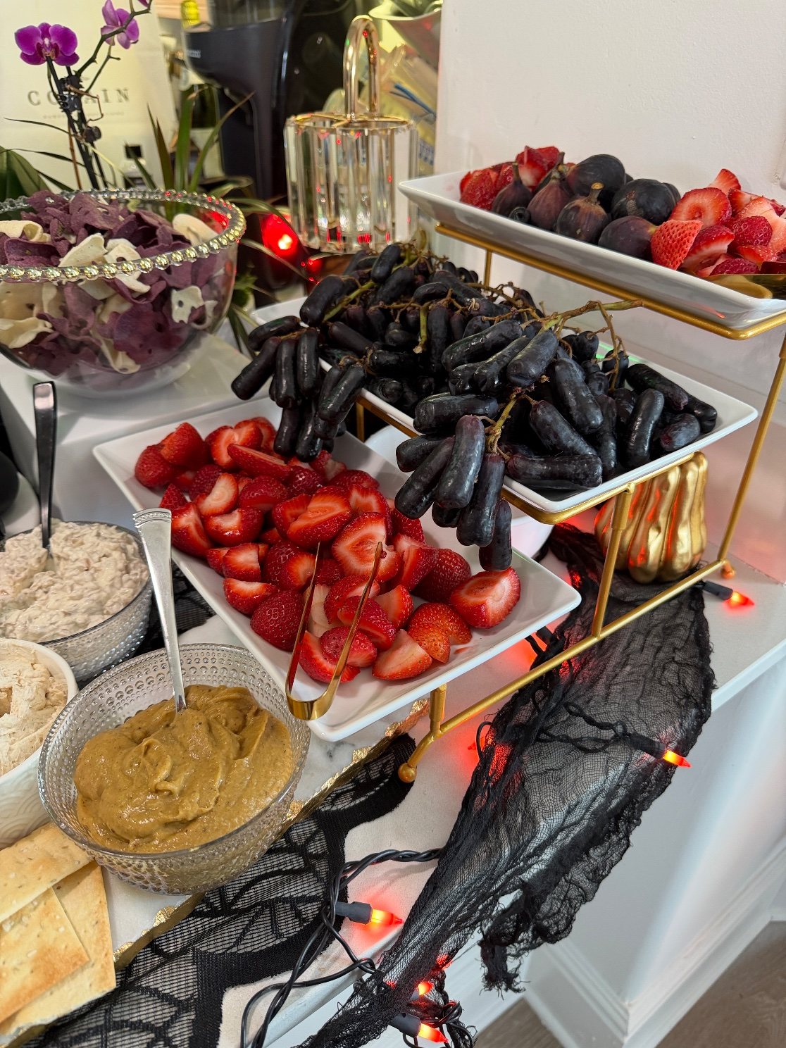 The tiered stand up close: figs and strawberries on top, moon grapes in the middle, with the pumpkin pie hummus alongside